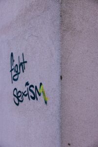 the words fight sexism written with paint on a wall
