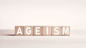 The word ageism on wooden blocks against white background.